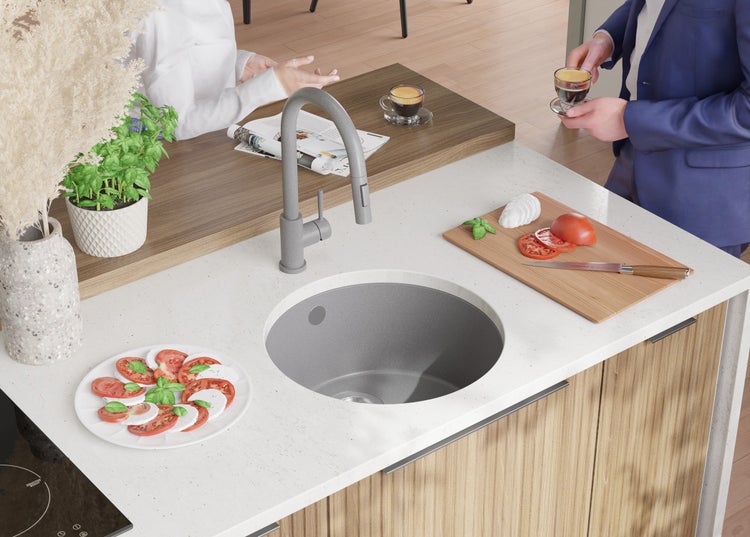 Küchenszene mit Spüle, Armatur, Arbeitsplatte und Lebensmitteln zur Zubereitung eines Salats