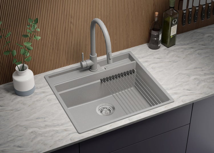 Graue Küchenspüle mit Abtropfgestell und Armatur auf einer Arbeitsplatte