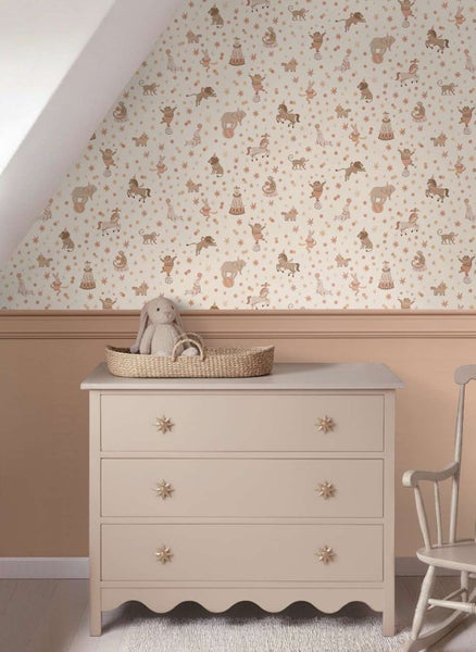 Kindertapete mit Zirkusmotiv und Tieren in einem Babyzimmer mit Kommode und Schaukelstuhl.