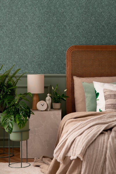 Wohnzimmer mit grüner Tapete mit geometrischem Muster, Sofa, Beistelltisch und Dekorationen