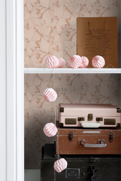 Dekoratives Arrangement mit Tapete, Lichterkette und gestapelten Koffern