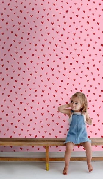 Rosa Tapete mit Herzmuster und ein Kind auf einer Bank