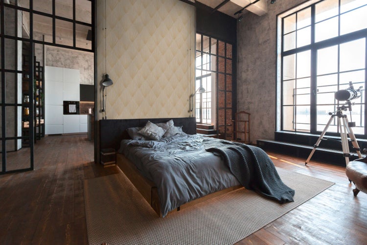 Wohnzimmer mit Sofa, Sesseln, Tischen und gemusterter Tapete für eine stilvolle Atmosphäre.