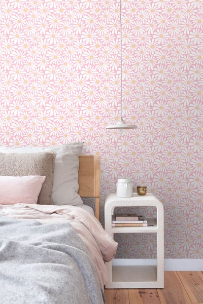 Schlafzimmer mit Bett, Nachttisch und Tapete mit Blumenmuster