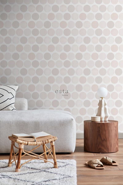 Heller Wohnraum mit Punktmuster-Tapete, Sofa, Tischlampe und Holzhocker