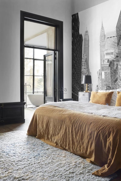 Schlafzimmer mit New Yorker Skyline-Tapete, Bett und offenem Badezimmer