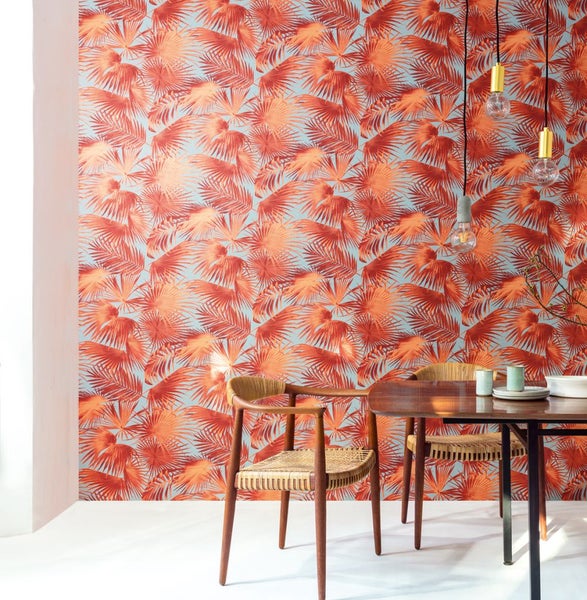 Esszimmer mit tropischer Palmenblatt Tapete, Esstisch und Stühlen.