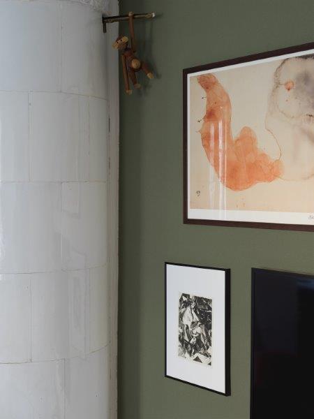 Detailaufnahme eines Zimmers mit einem Kamin, Bildern an der Wand und einer Holzaffenfigur