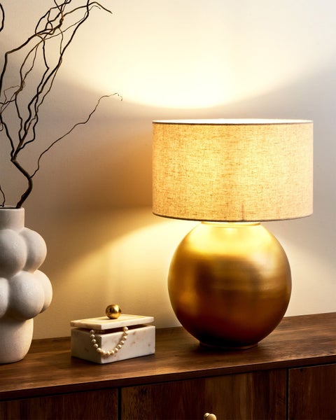 Dekoratives Interieur mit Tischleuchte, Vase und Schmuckschatulle auf einem Holzschrank