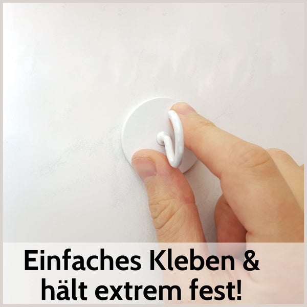 Weißer runder Klebehaken wird von einer Hand an eine Wand gedrückt. Text: Einfaches Kleben und hält extrem fest.