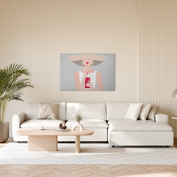 Wohnzimmer mit Sofa, Tisch und einem gerahmten Bild einer Frau mit Hut, die einen Drink genießt.