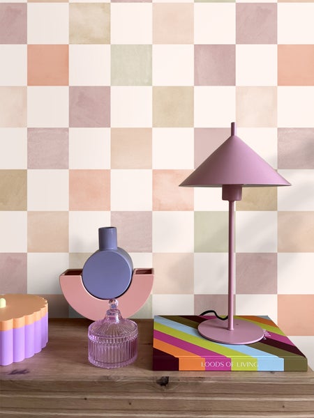 Dekorative Szene mit Lampe, Vase und Schmuckkästchen auf einem Holzmöbel vor einer karierten Wand