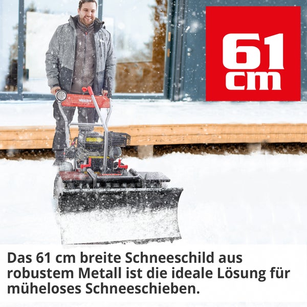 Mann benutzt eine Hecht Schneefräse zum Schneeräumen vor einem Haus.