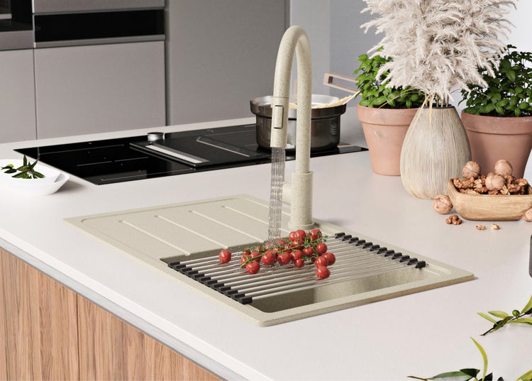 Spüle mit Abtropfgestell, Armatur und Gemüse in einer hellen Küche