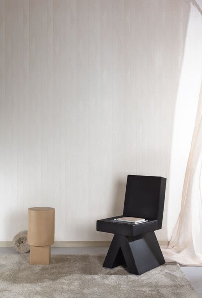 Wohnszene mit gemusterter Tapete, Stuhl und Teppich für ein helles Ambiente.