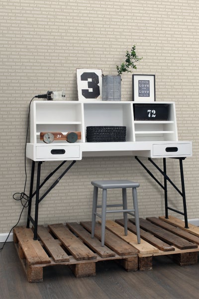 Einrichtungsszene mit Schreibtisch, Hocker und Dekoration auf Paletten
