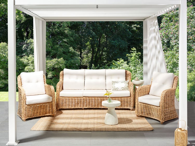 Terrasse mit Rattansitzgruppe unter einer Pergola