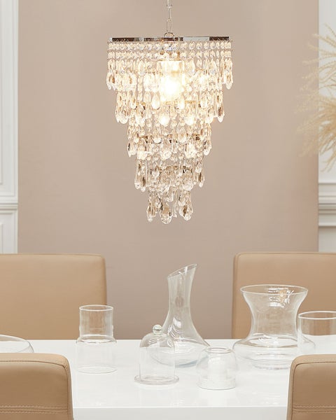 Szene mit Kristall-Hängeleuchte über Esstisch mit Glaswaren