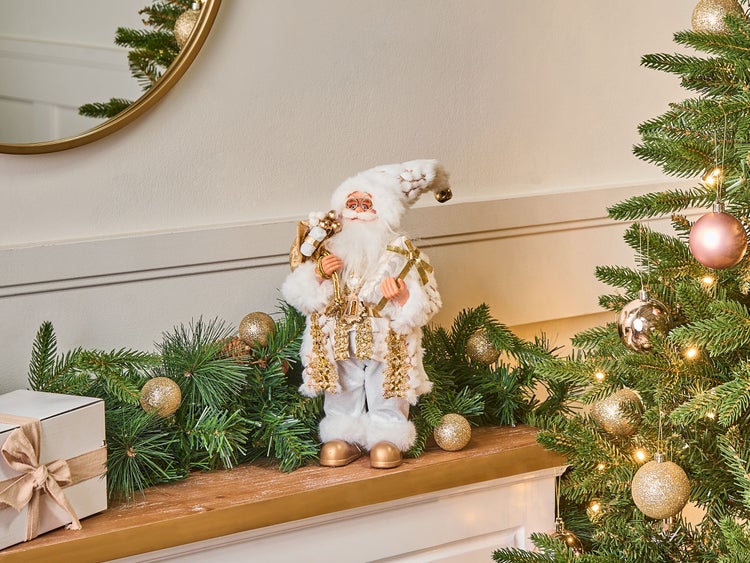 Dekorative Weihnachtsszene mit Weihnachtsmannfigur, Tannengirlande und geschmücktem Weihnachtsbaum