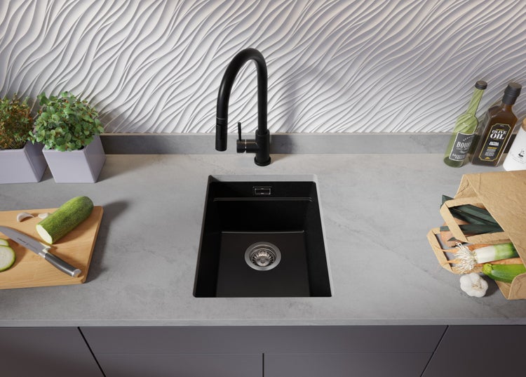 Küchenspüle aus Granit mit Armatur auf einer Arbeitsplatte mit Lebensmitteln