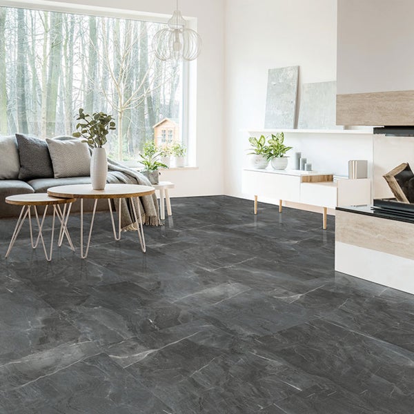 Heller Wohnraum mit Sofa, Tisch und dunkelgrauem Bodenbelag in Marmoroptik