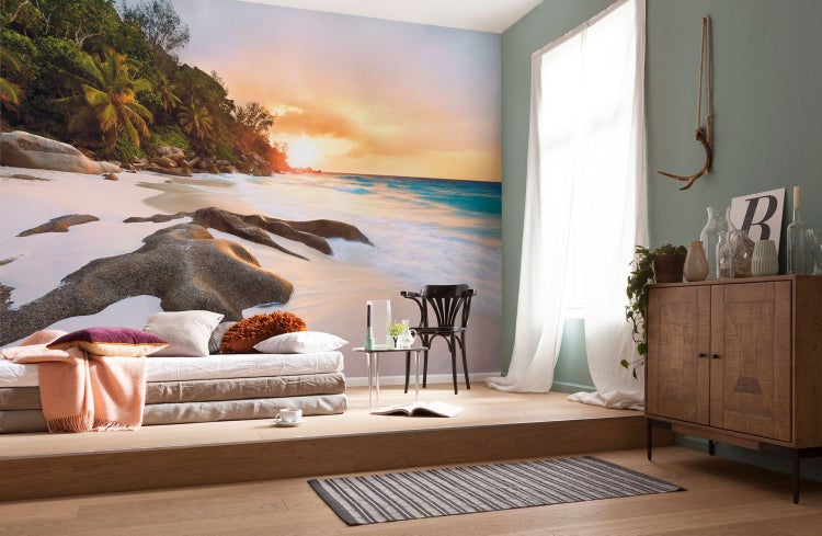 Wohnzimmer mit Fototapete, die einen Strand bei Sonnenuntergang darstellt