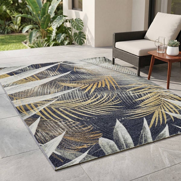 Rechteckiger Outdoor-Teppich mit Blattmuster auf einer Terrasse mit Loungemöbeln und tropischen Pflanzen.