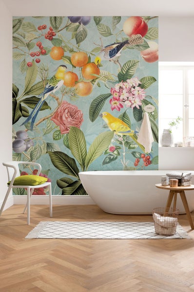 Helles Badezimmer mit floraler Tapete mit Vogelmotiven, Badewanne, Stuhl und Holzboden