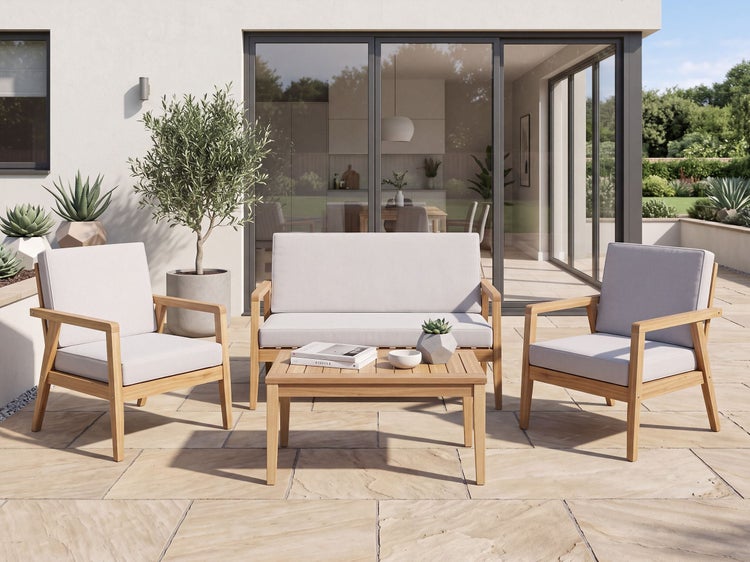 Moderne Gartenlounge aus Holz mit zwei Sesseln, einem Sofa und einem Couchtisch auf einer Steinterrasse vor einer bodentiefen Glasfront.