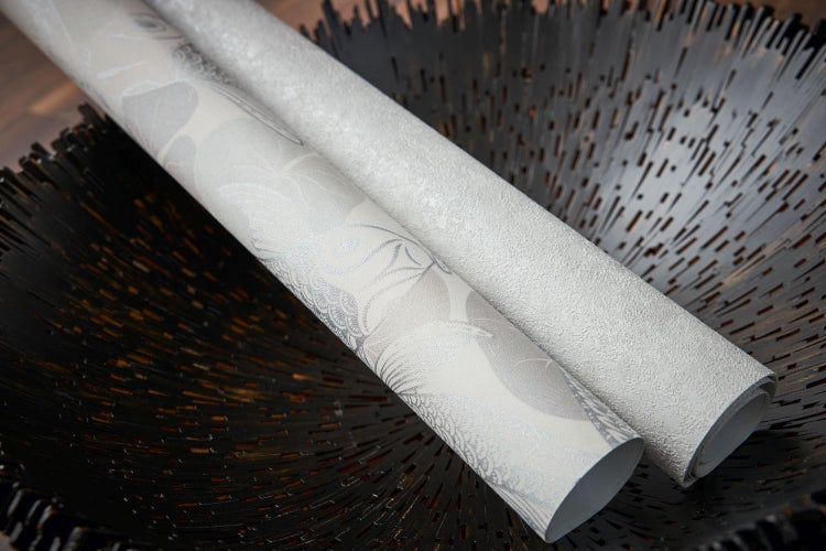 Wohnraum mit floral gemusterter Tapete, Sessel und Tisch