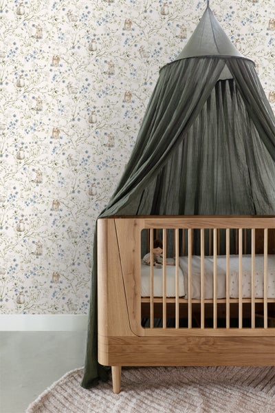 Dekoratives Zimmer mit Tapete, Rattansessel und Beistelltischen.