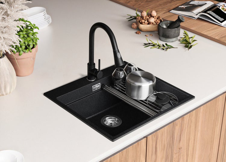 Spüle mit Armatur, Abtropfgestell und Spülbecken auf einer Küchentheke.