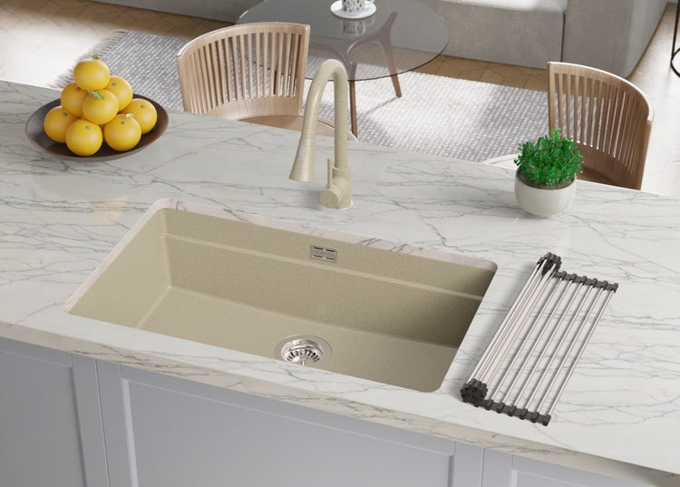 Küchenspüle mit Abtropfgestell, Armatur, Obstschale und Topfpflanze auf einer Küchentheke