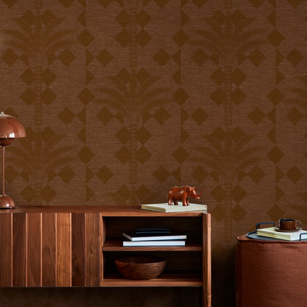 Tapete mit Palmen- und Rautenmuster in einem modern und geordnet eingerichteten Raum mit Sideboard aus Holz.