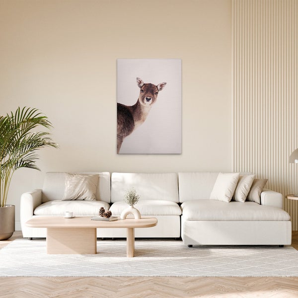 Dekoratives Hirsch-Leinwandbild über einem Sofa in einem Wohnzimmer.