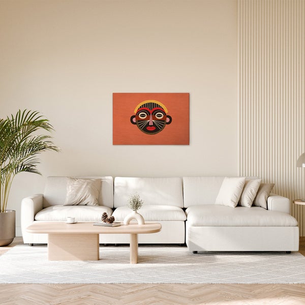 Gemälde einer afrikanischen Maske über einem weißen Sofa in einem Wohnzimmer