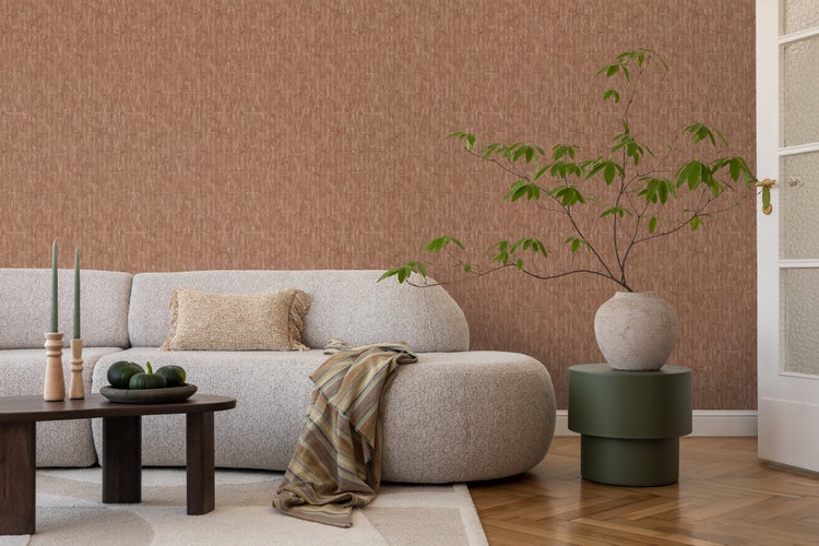 Einrichtung eines Wohnzimmers mit Sofa, Couchtisch und Dekorationen vor einer gemusterten Tapete