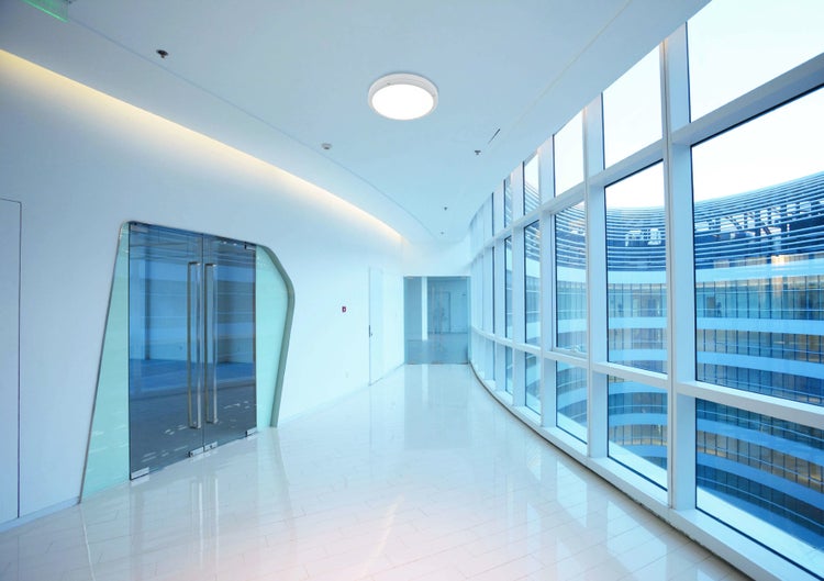 Heller Flur mit Glaswand, Glastür und runder Deckenleuchte