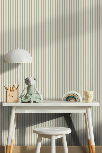 Kinderzimmer mit Schreibtisch, Stuhl, Lampe und Spielzeug vor gestreifter Tapete