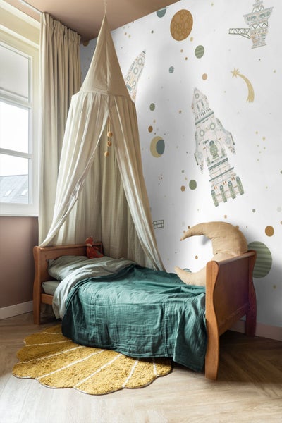 Kinderzimmer mit Holzbett, Betthimmel und Tapete mit Weltraum-Motiven wie Raketen, Planeten und Sternen.