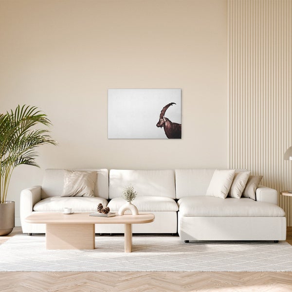 Wohnzimmer mit Sofa, Couchtisch und Wandbild eines Steinbocks