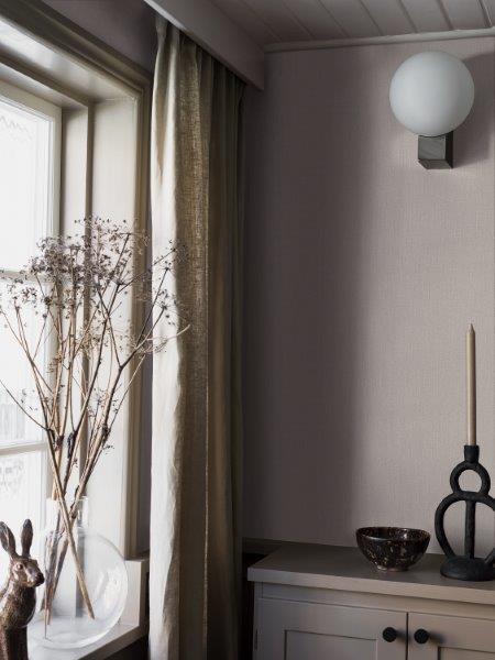 Dekoratives Arrangement mit Topfpflanze und Vasen auf einem Sideboard