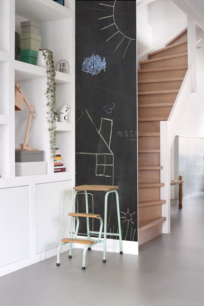 Szene mit einer Tafel mit Kreidezeichnungen, einem Tritt und einer Holztreppe neben einem eingebauten Regal.
