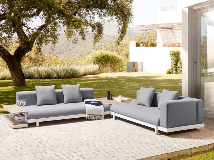 Gartenlounge-Set auf einer Terrasse mit Baum im Hintergrund