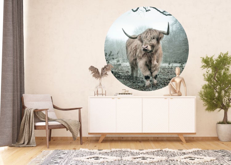 Raumansicht mit Kommode, Stuhl, Teppich und Wandbild mit schottischem Hochlandrind