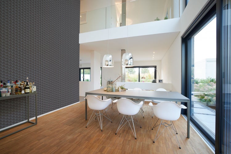 Heller Speisesaal mit Esstisch, Stühlen, Regal und gemusterter Tapete