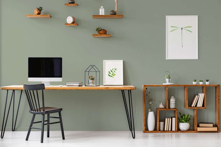 Hell gestalteter, organisierter Arbeitsplatz mit einem Holzschreibtisch, schwarzen Haarnadelbeinen und einem offenen Standregal aus Holz.