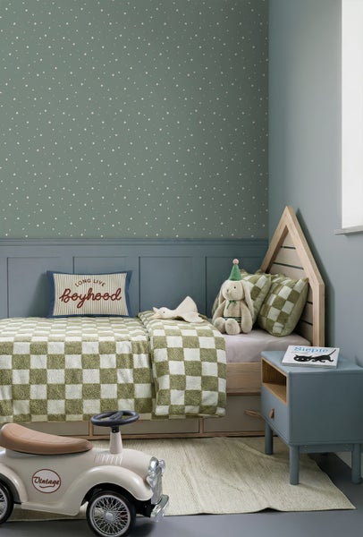 Kinderzimmer mit Sternen-Tapete in Salbeigrün, blauer Wandtäfelung, Holz-Hausbett und grün-weiß karierter Bettwäsche.