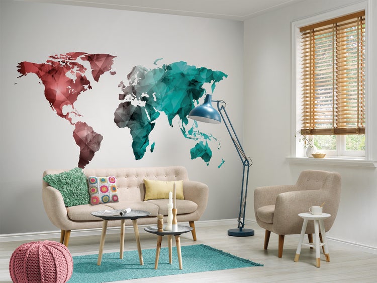 Wandtattoo Weltkarte im polygonalen Design in einem modern eingerichteten Wohnzimmer mit Sofa, Sessel und Fenster mit Holzjalousien.