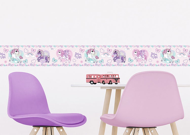 Hell gestaltetes Kinderzimmer mit einer dekorativen Wandbordüre mit Einhornmotiven über einem kleinen Tisch und zwei Stühlen.